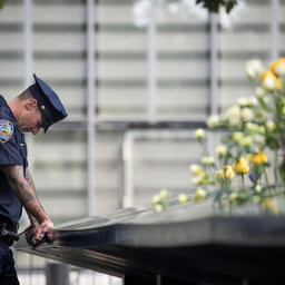 A New York City Police Department (NYPD) officer pauses while visiting the North pool during a commemoration ceremony for the victims of the September 11 terrorist attacks at the National September 11 Memorial,
