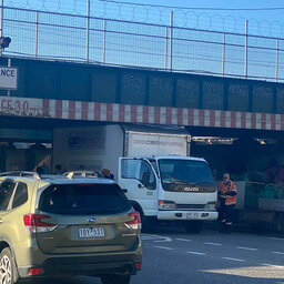 A truck is stuck under the Montague Street Bridge