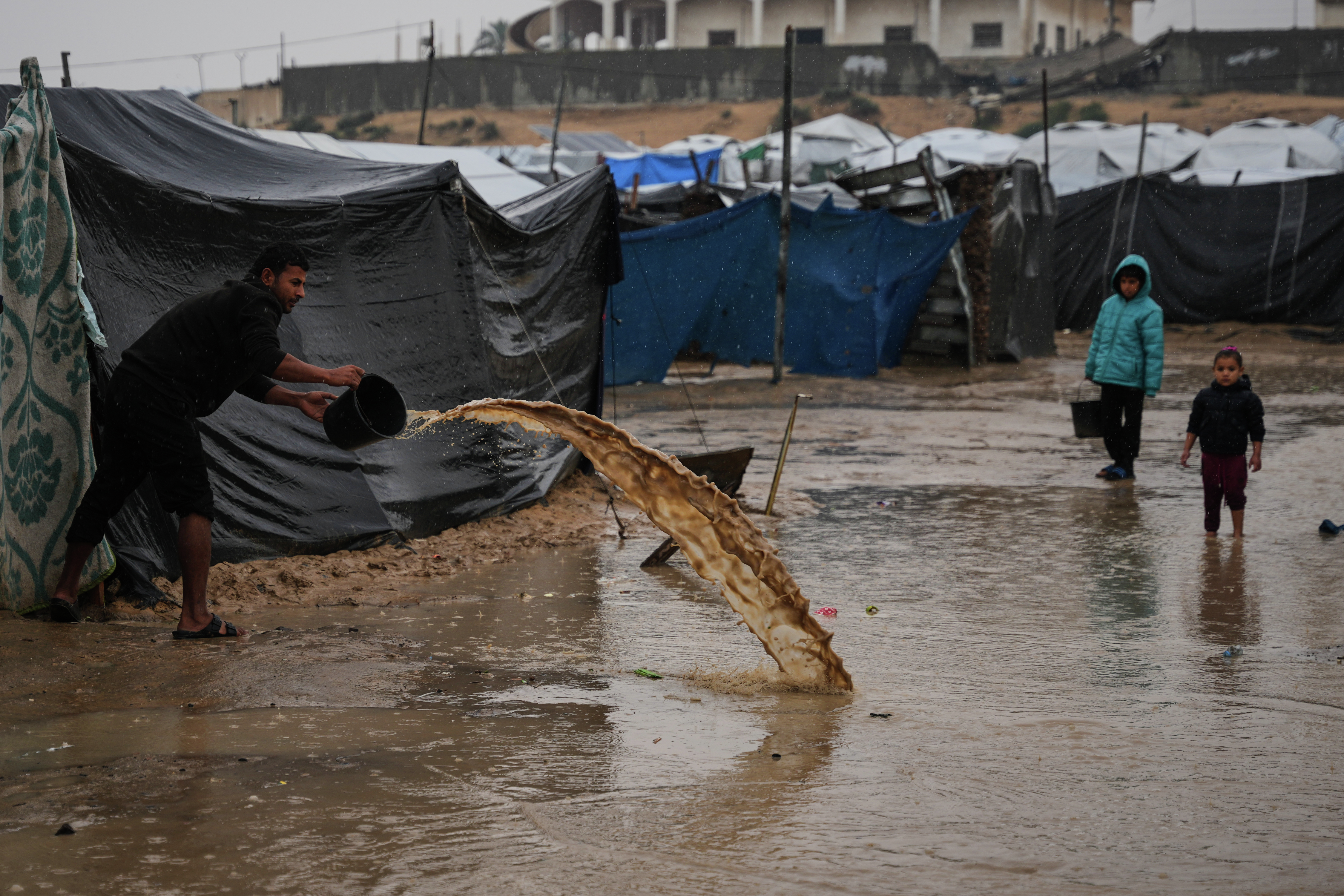 Storm worsens living conditions: A families dig trenches to keep water out of tents